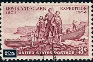 Old 3 cent US stamp with an illustration of the Lewis & Clark expedition, in front of their boat with Sacagawea.